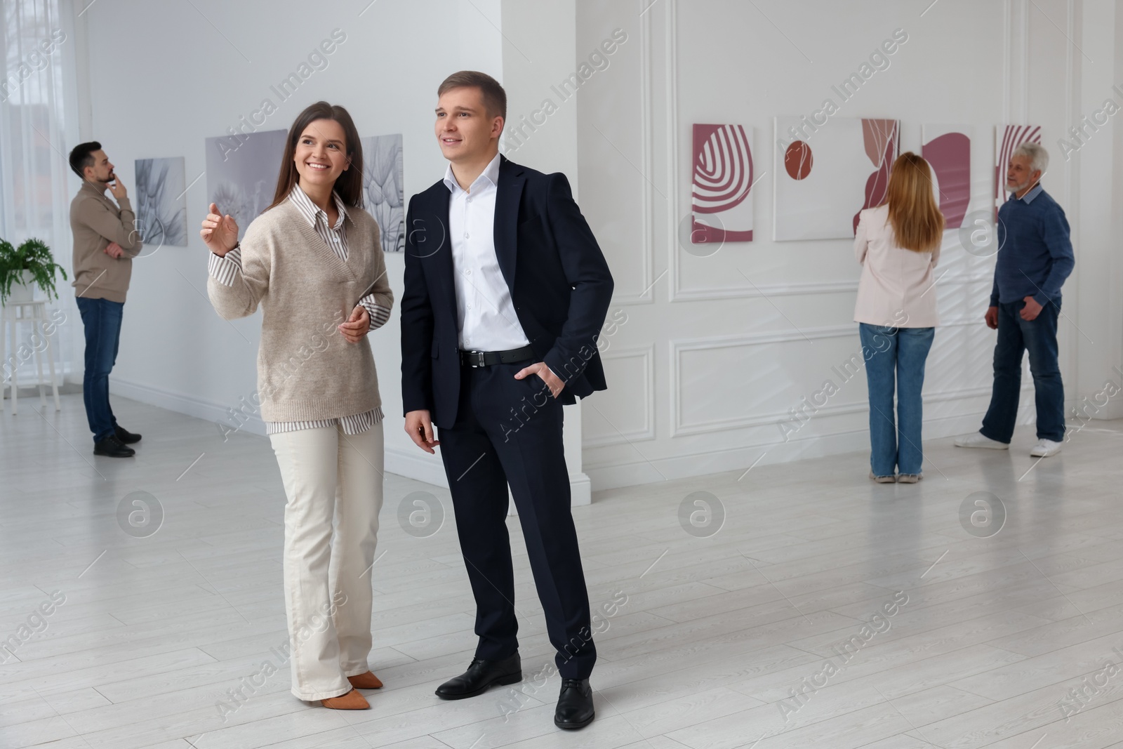 Photo of Happy woman and man visiting art gallery