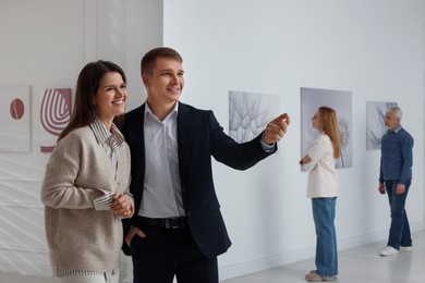 Happy woman and man visiting art gallery