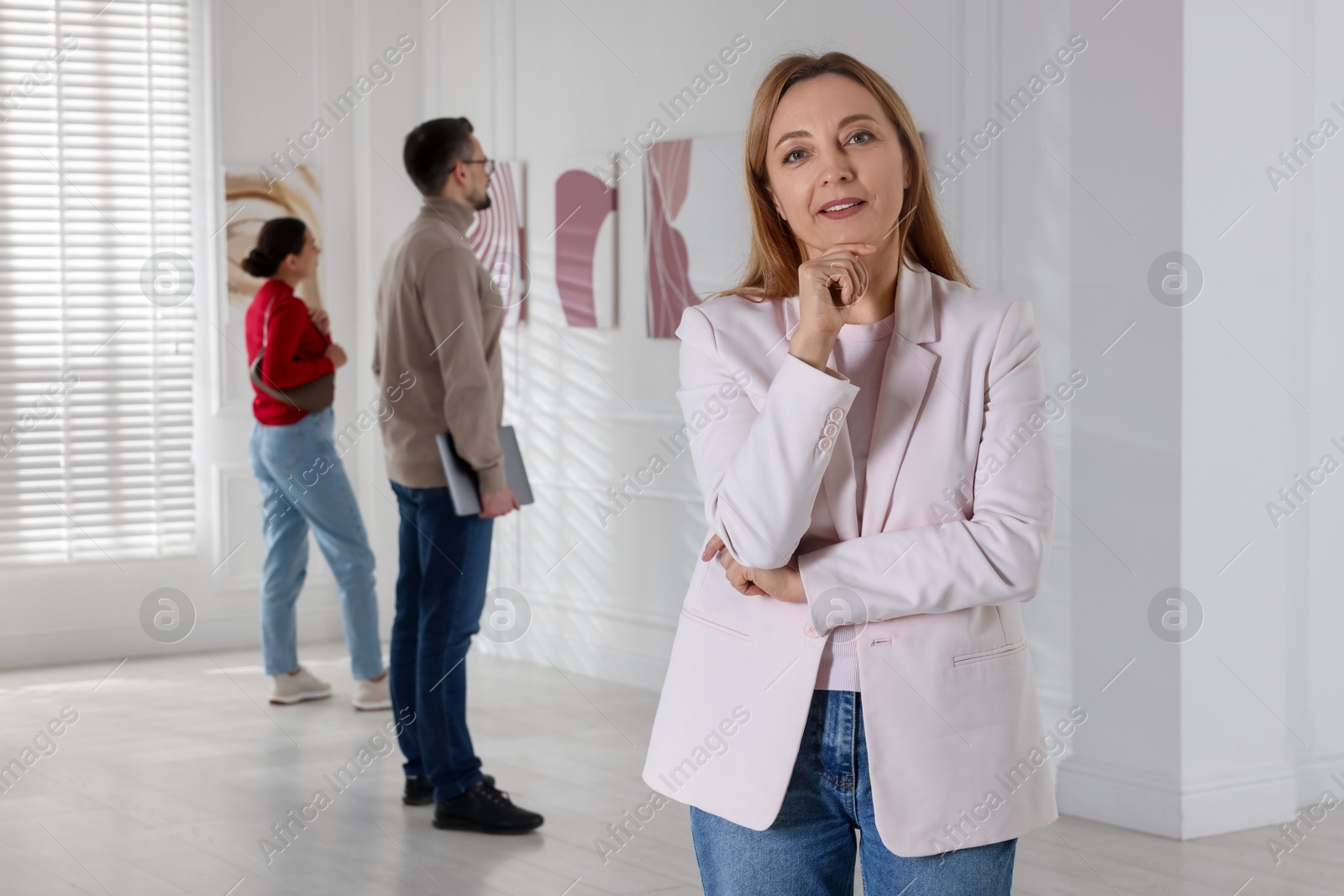 Photo of Beautiful woman enjoying art in modern gallery