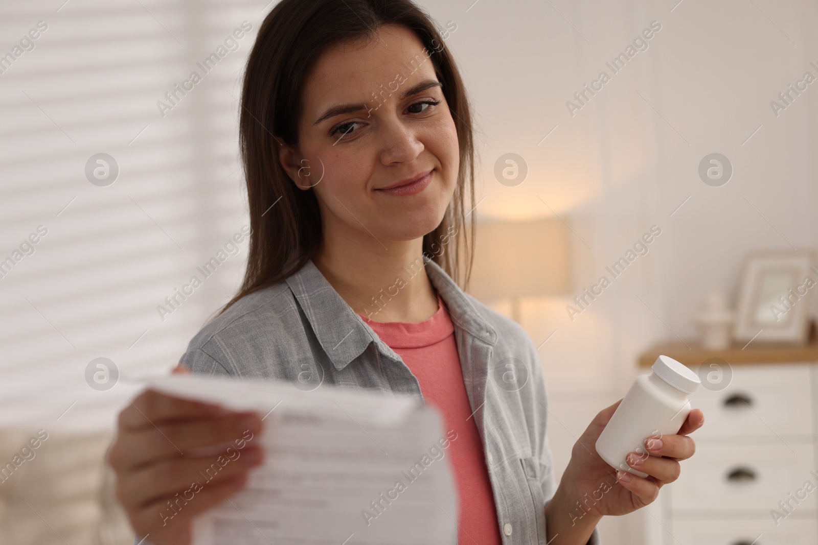 Photo of Woman with pills reading instruction at home