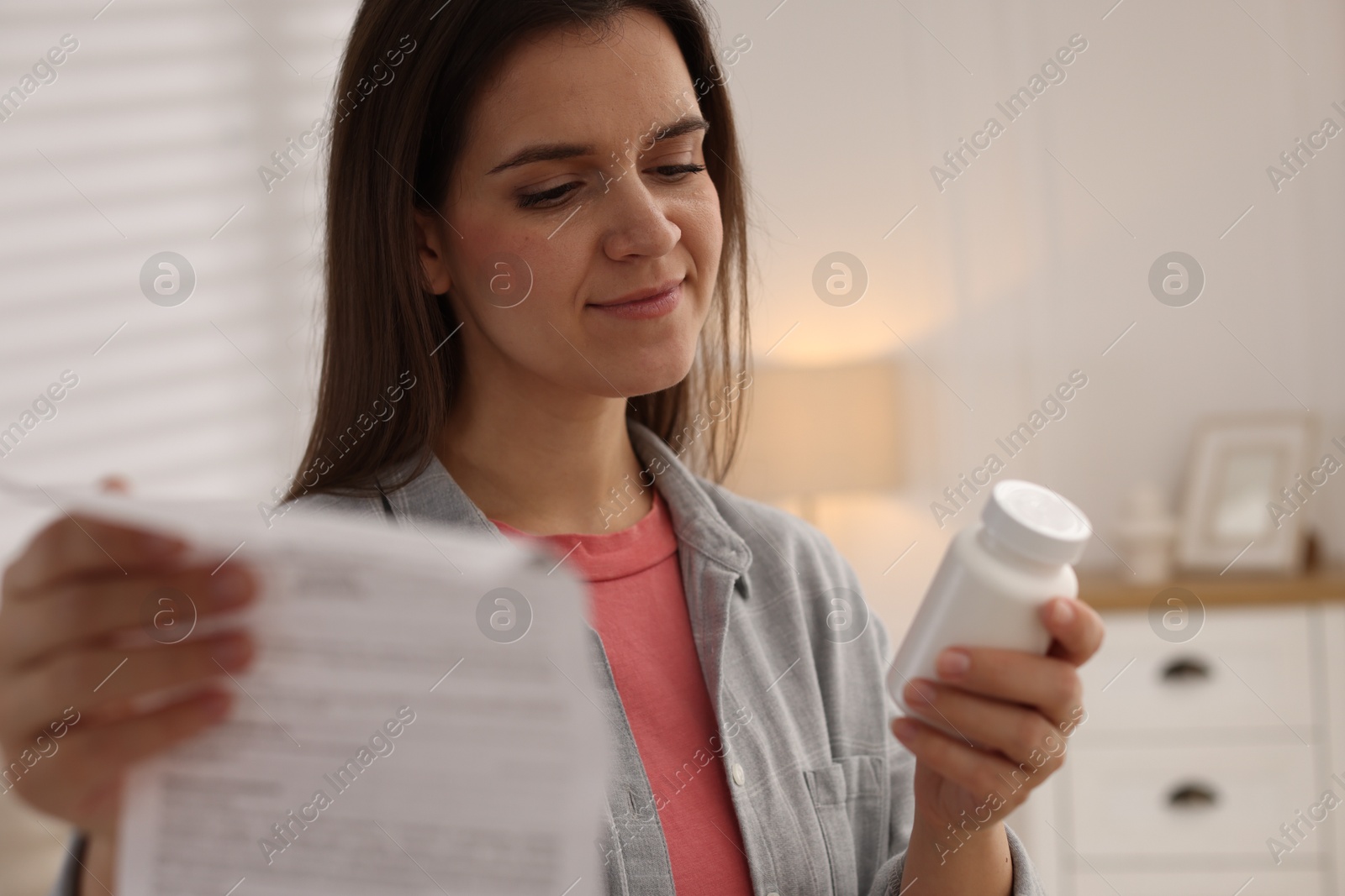 Photo of Woman with pills and medical instruction at home