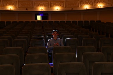 Photo of Young man watching theatrical performance in theatre