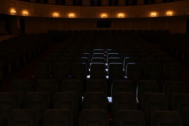 Photo of Rows of comfortable seats illuminated by spotlight in theatre