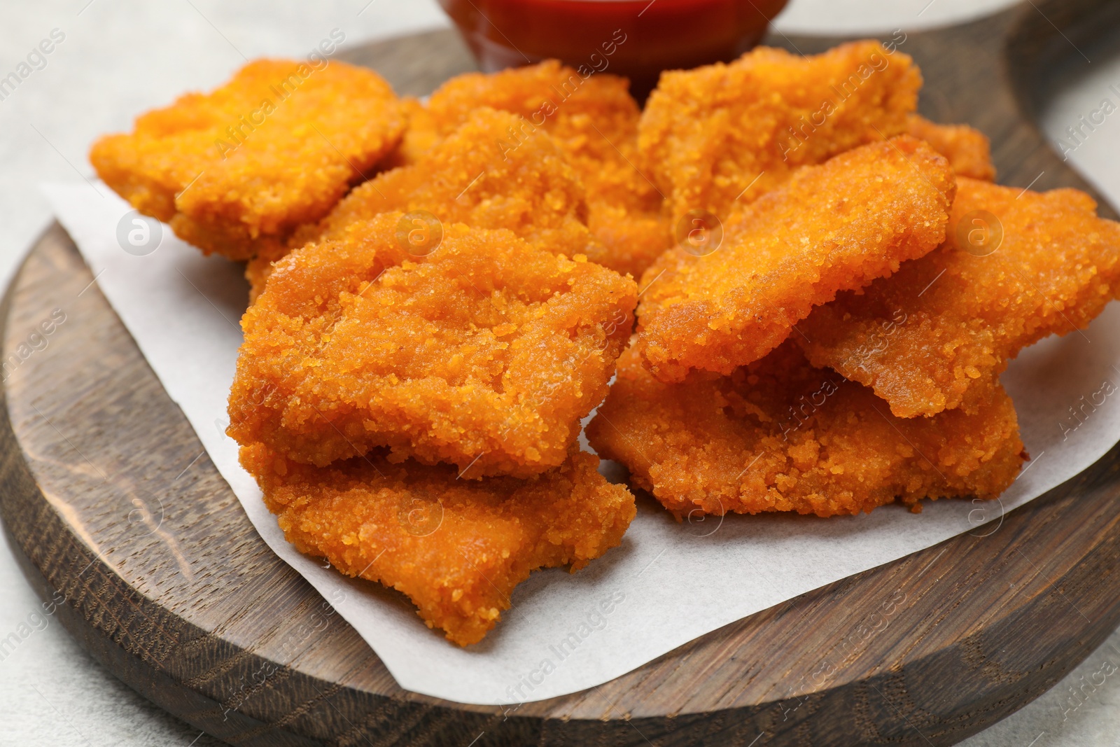 Photo of Delicious chicken nuggets on grey table, closeup