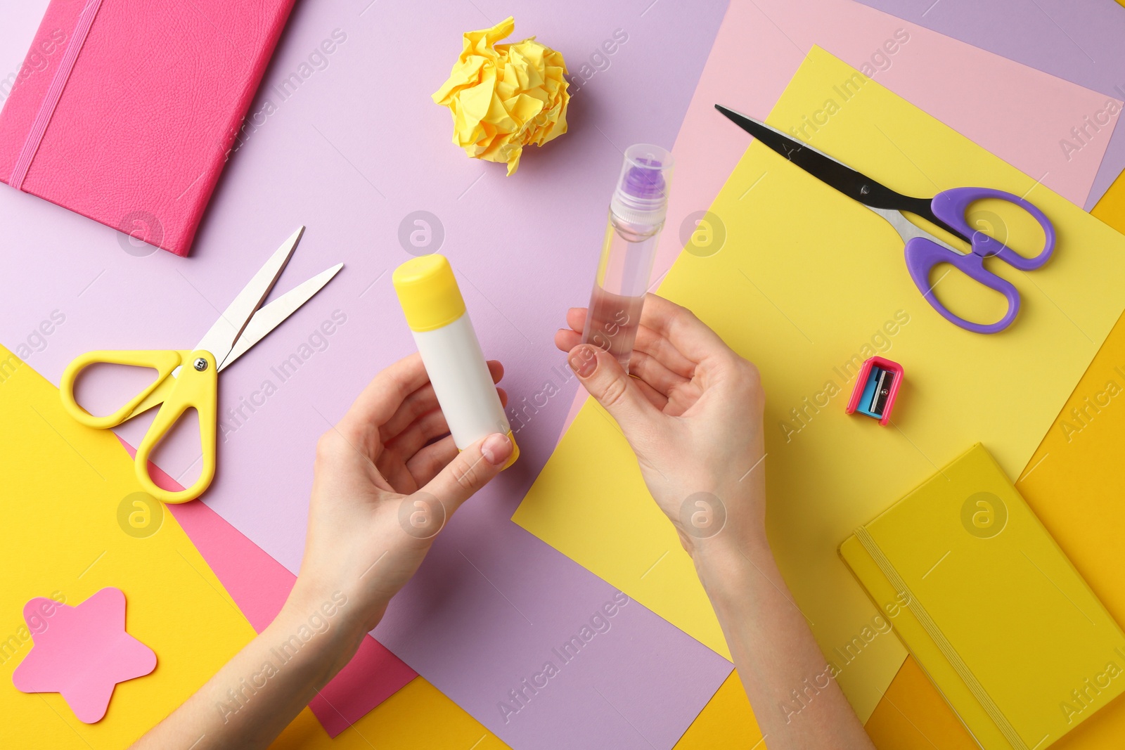 Photo of Woman with glue, scissors and colorful paper at table, top view