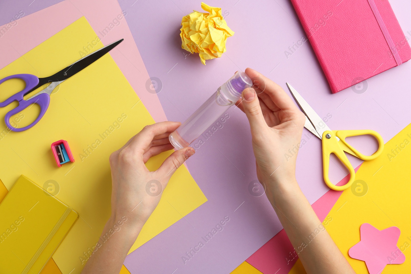 Photo of Woman with glue, scissors and colorful paper at table, top view