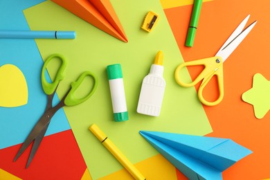 Photo of Flat lay composition with glue, scissors and other stationery on color background