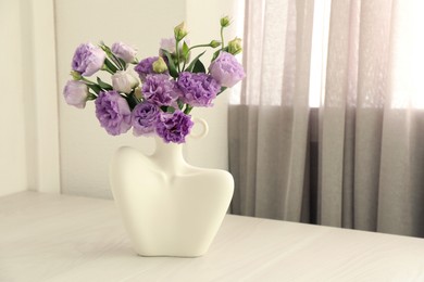 Photo of Stylish vase with beautiful flowers on white wooden table at home, space for text