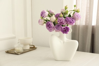 Photo of Stylish vase with beautiful flowers and decor on white wooden table at home