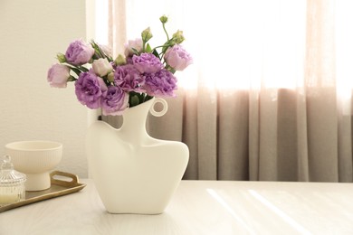 Photo of Stylish vase with beautiful flowers and decor on white wooden table at home, space for text