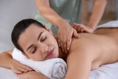 Young woman receiving massage in spa salon