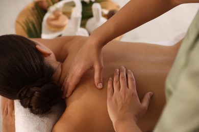 Photo of Woman receiving back massage in spa salon