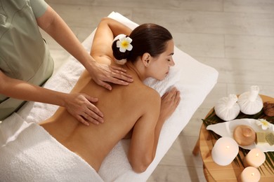 Photo of Woman receiving back massage in spa salon, top view