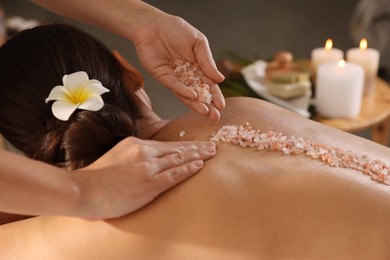 Photo of Woman receiving massage with sea salt in spa salon