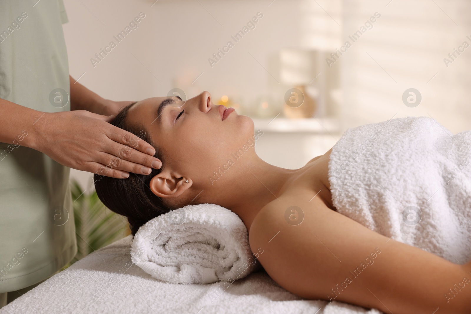 Photo of Young woman receiving massage in spa salon