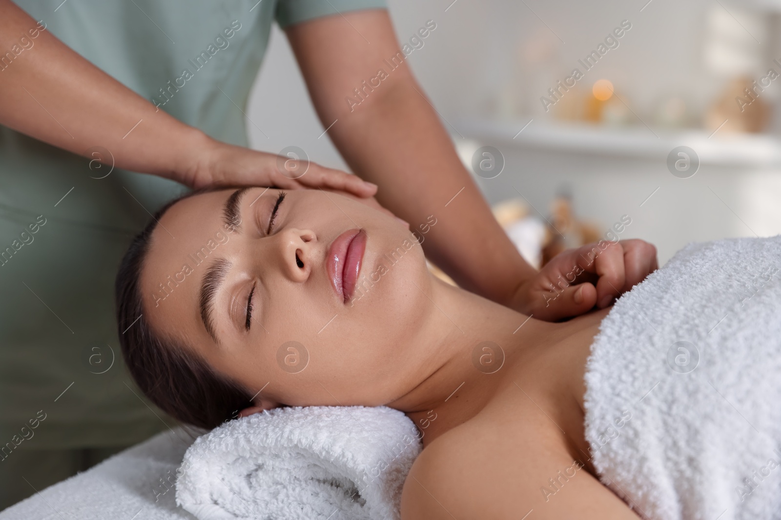 Photo of Young woman receiving massage in spa salon