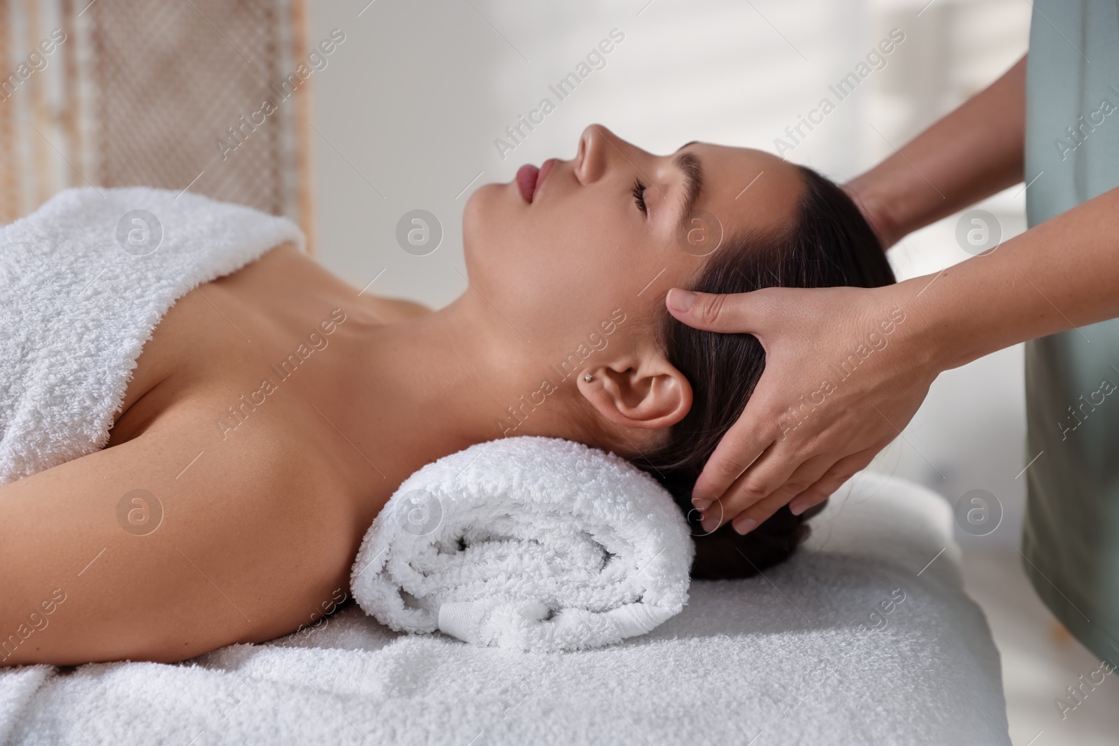 Photo of Young woman receiving massage in spa salon