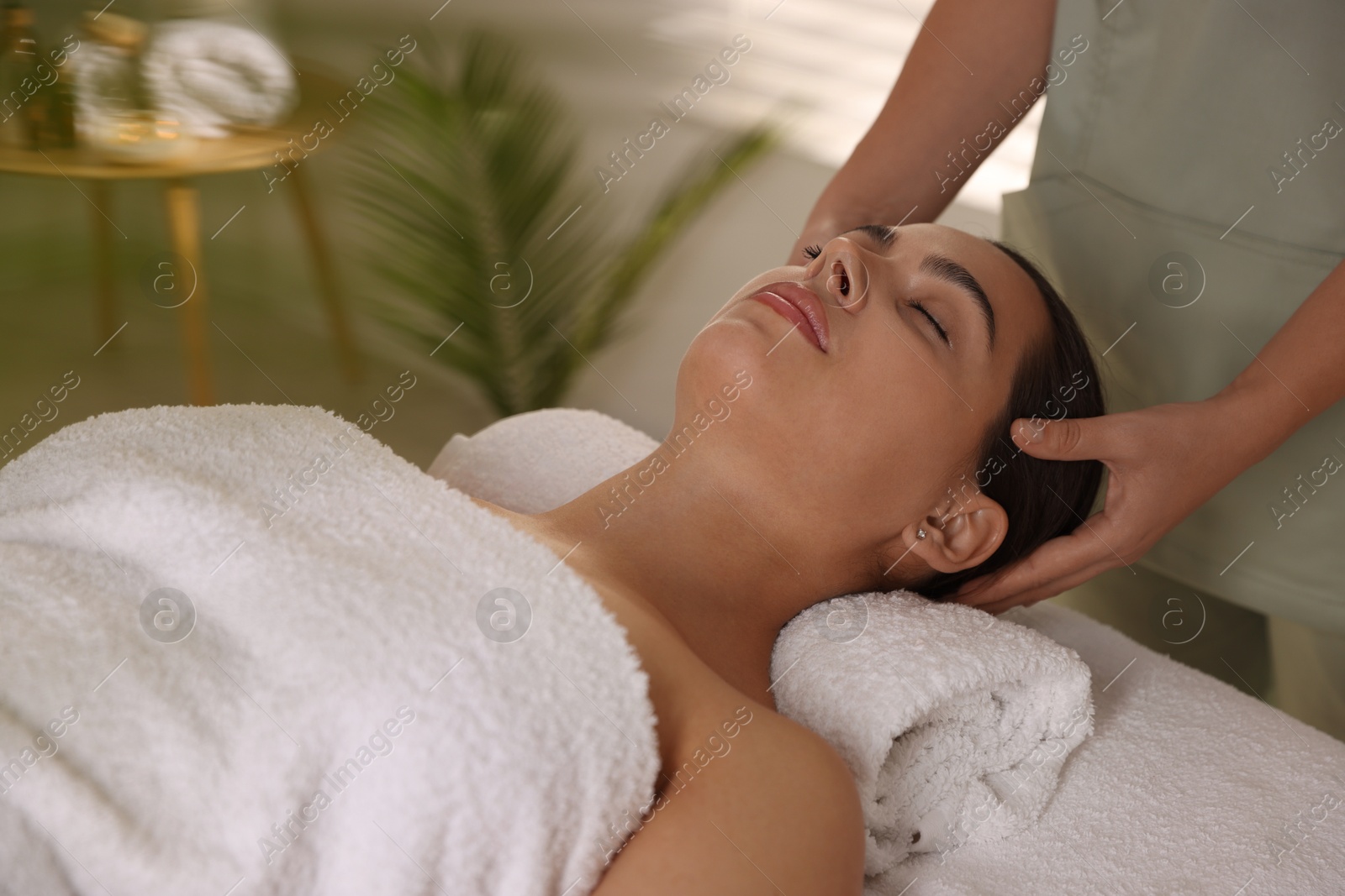 Photo of Young woman receiving massage in spa salon