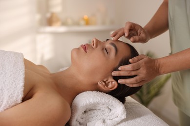 Woman receiving face massage in spa salon