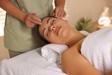 Woman receiving face massage in spa salon