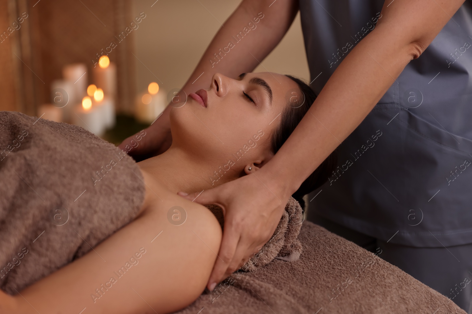 Photo of Young woman receiving massage in spa salon