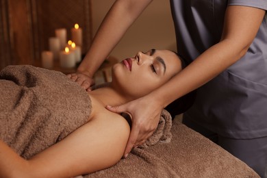 Photo of Young woman receiving massage in spa salon