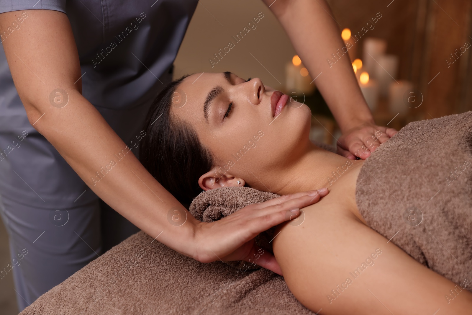 Photo of Young woman receiving massage in spa salon