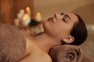 Woman lying on massage table in spa salon