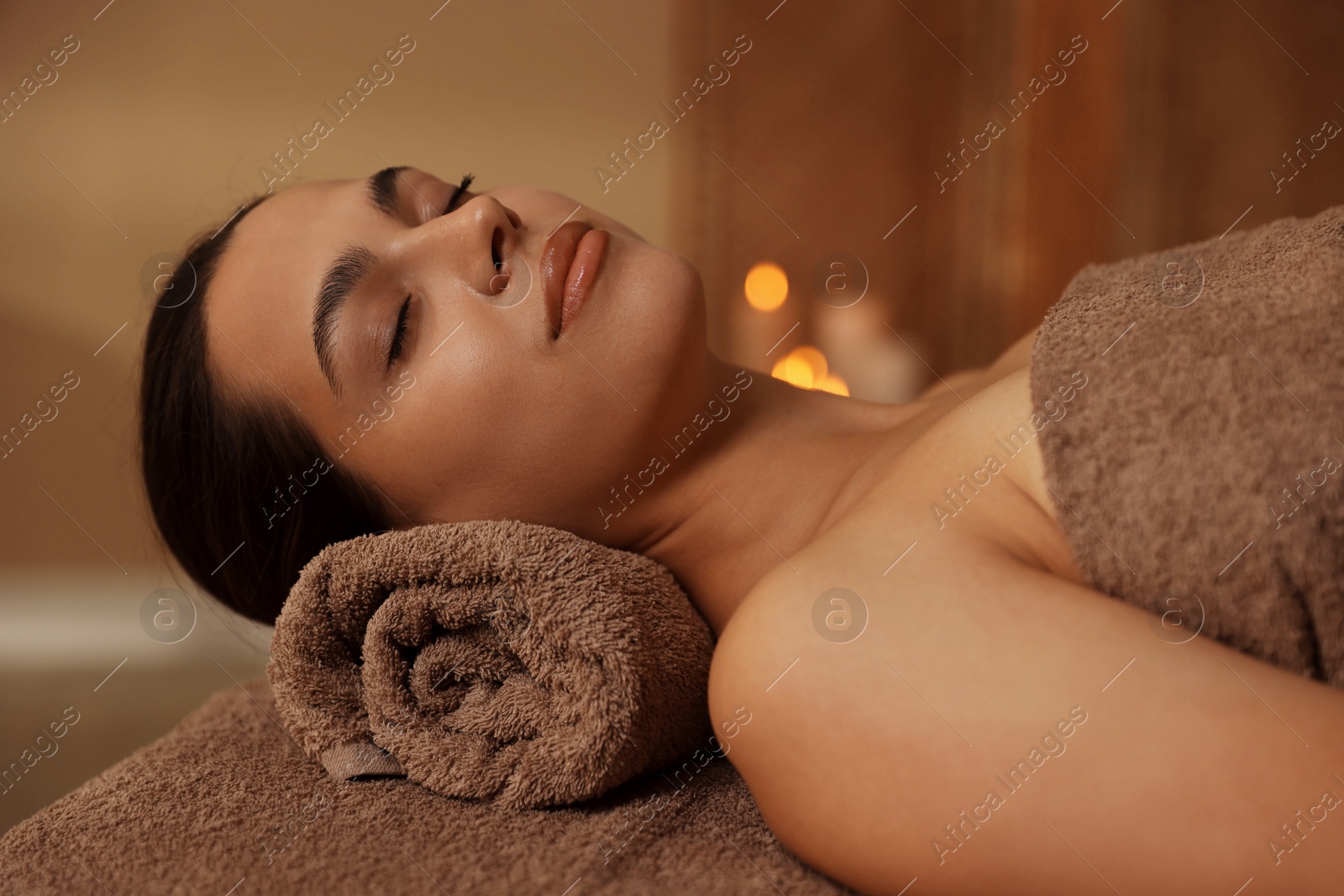 Photo of Woman lying on massage table in spa salon