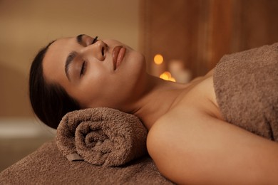 Photo of Woman lying on massage table in spa salon