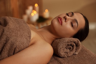 Photo of Woman lying on massage table in spa salon