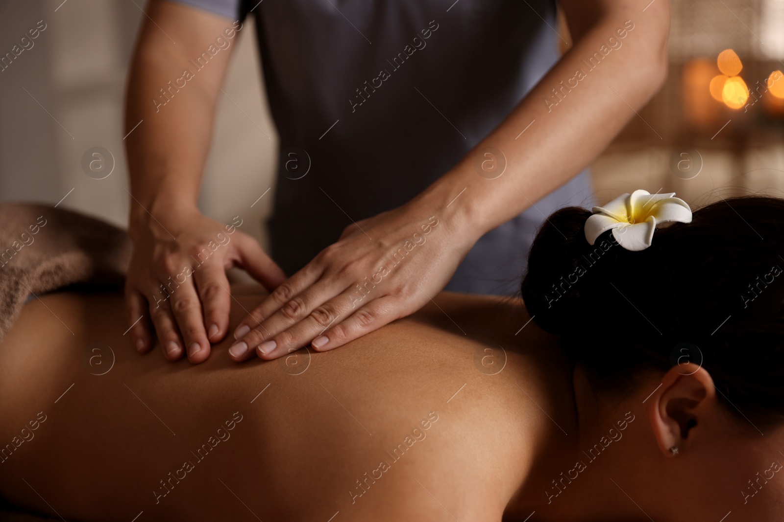 Photo of Woman receiving back massage in spa salon, closeup