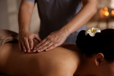 Photo of Woman receiving back massage in spa salon, closeup