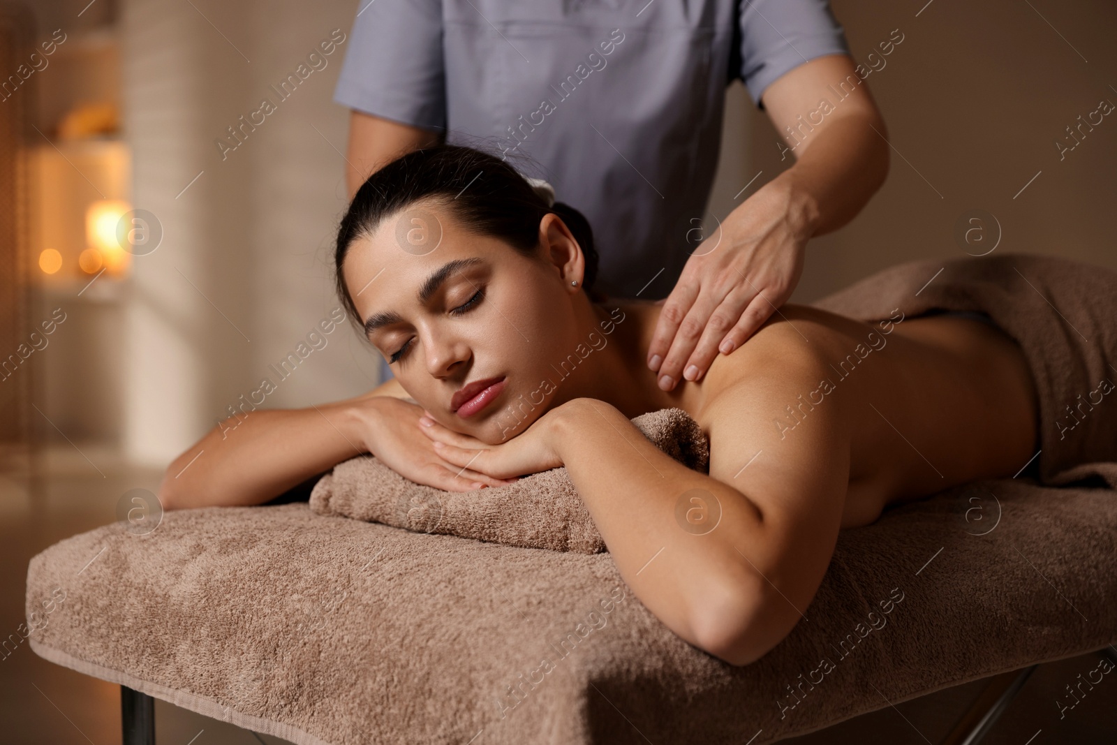 Photo of Woman receiving back massage in spa salon