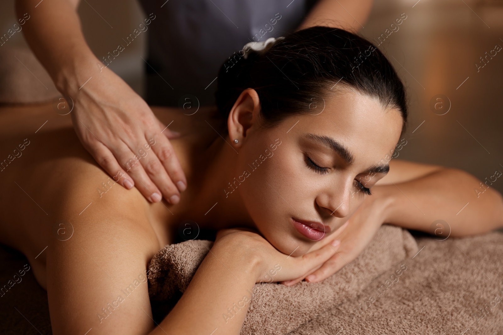 Photo of Woman receiving back massage in spa salon