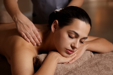 Woman receiving back massage in spa salon