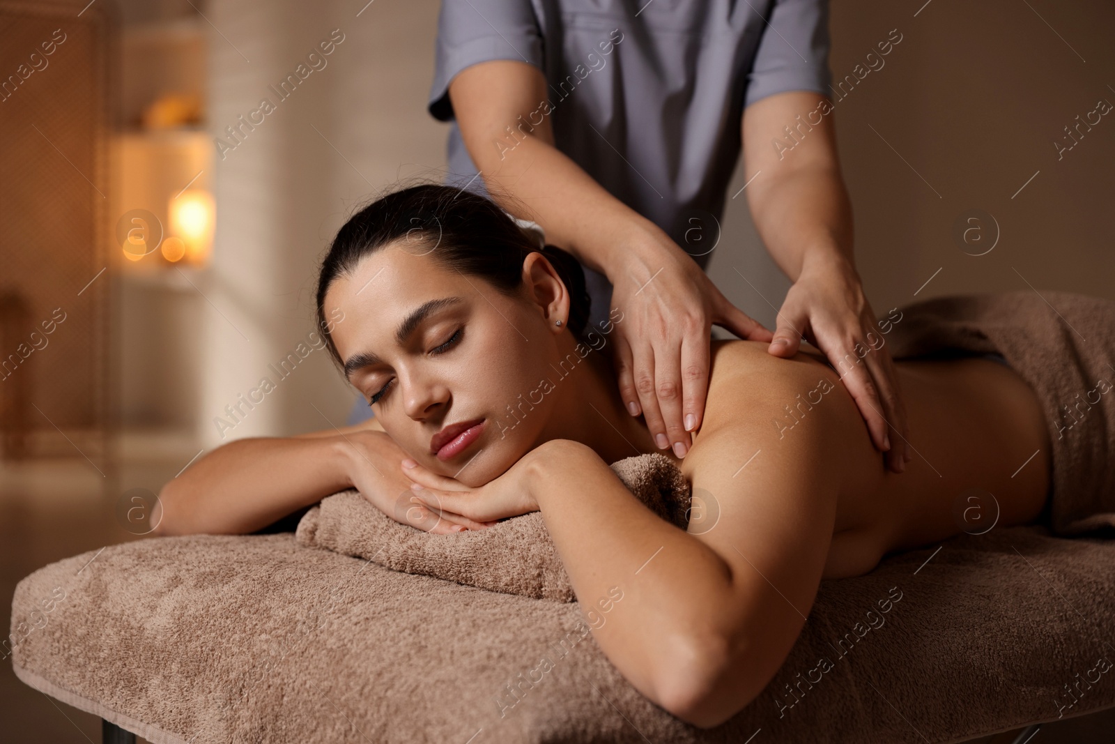 Photo of Woman receiving back massage in spa salon