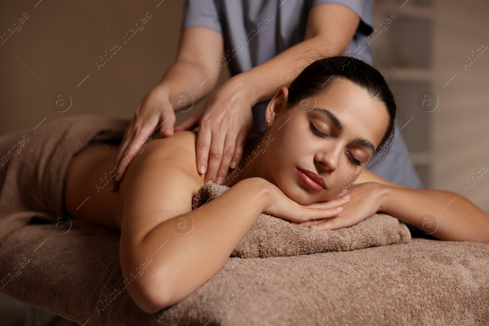 Photo of Woman receiving back massage in spa salon