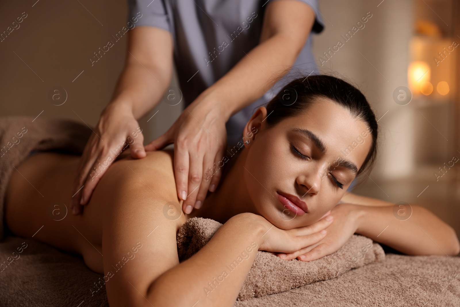 Photo of Woman receiving back massage in spa salon