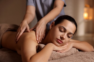 Photo of Woman receiving back massage in spa salon