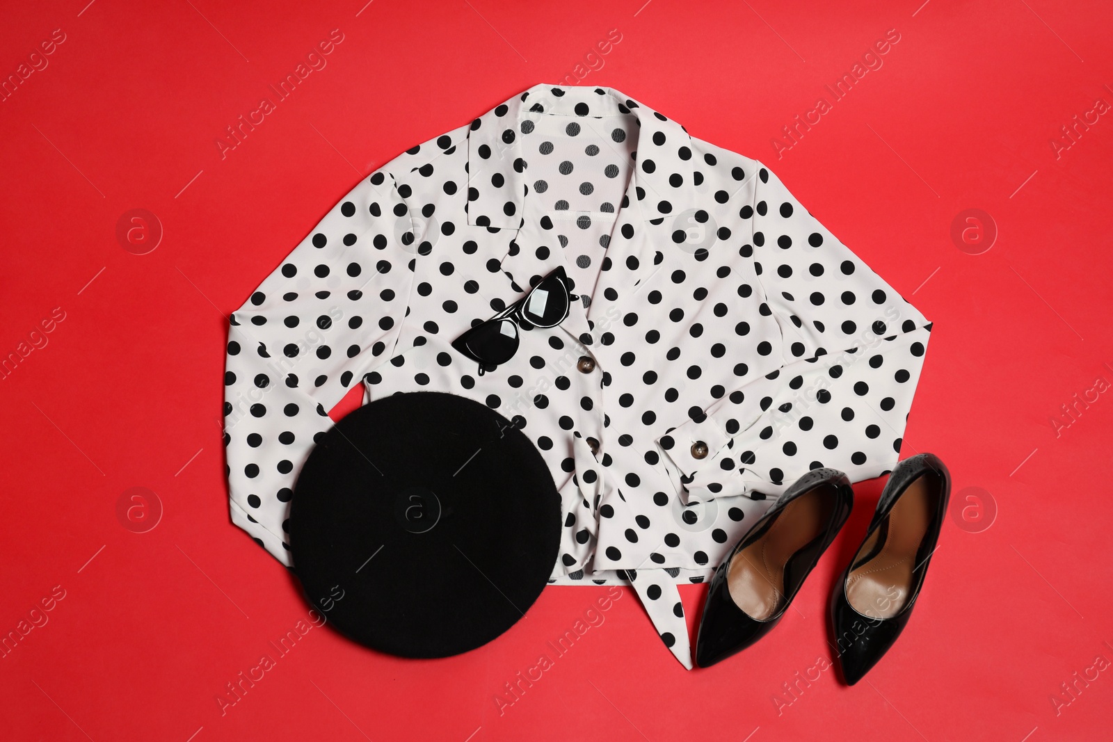 Photo of Retro styled outfit on red background, flat lay