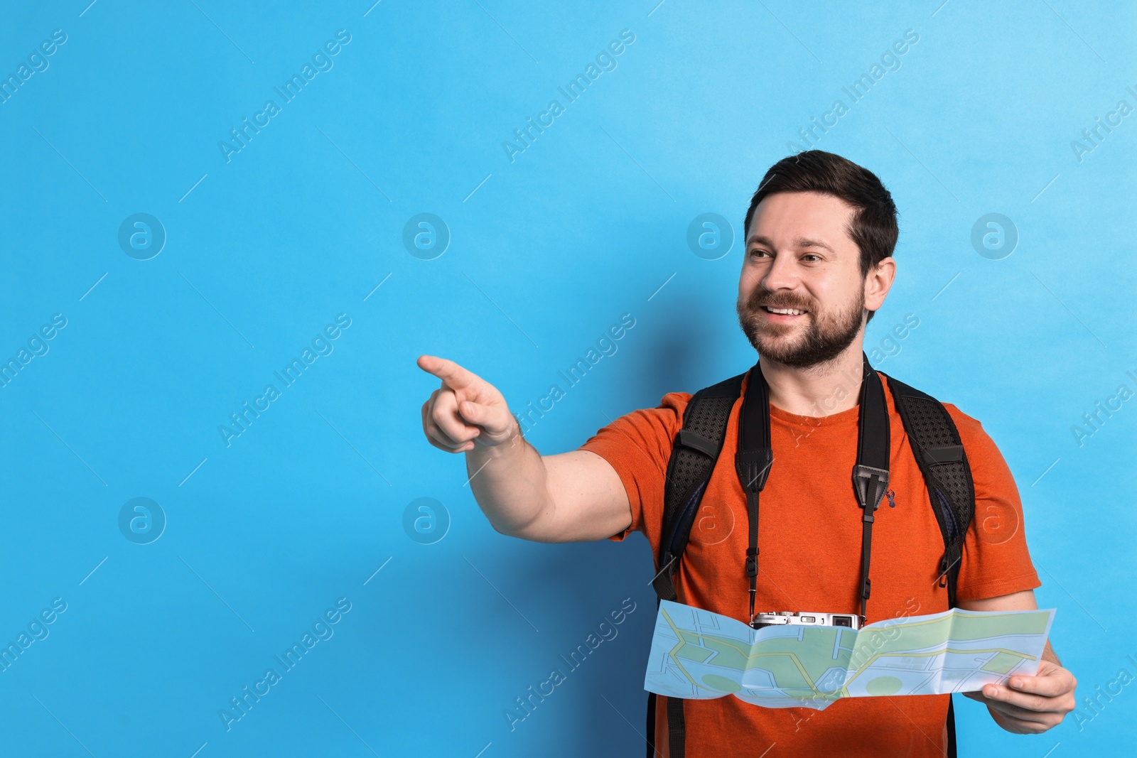 Photo of Traveller with camera and map on light blue background, space for text