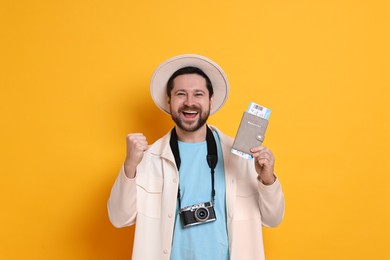 Photo of Traveller with vintage camera, passport and ticket on orange background