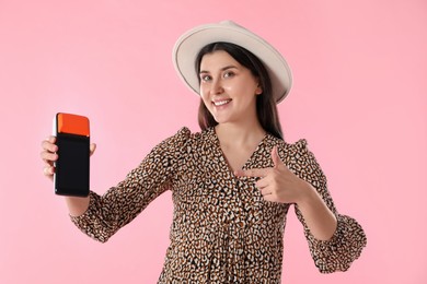 Photo of Happy young woman with payment terminal on pink background