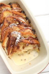 Photo of Freshly baked bread pudding in baking dish on white wooden table, top view