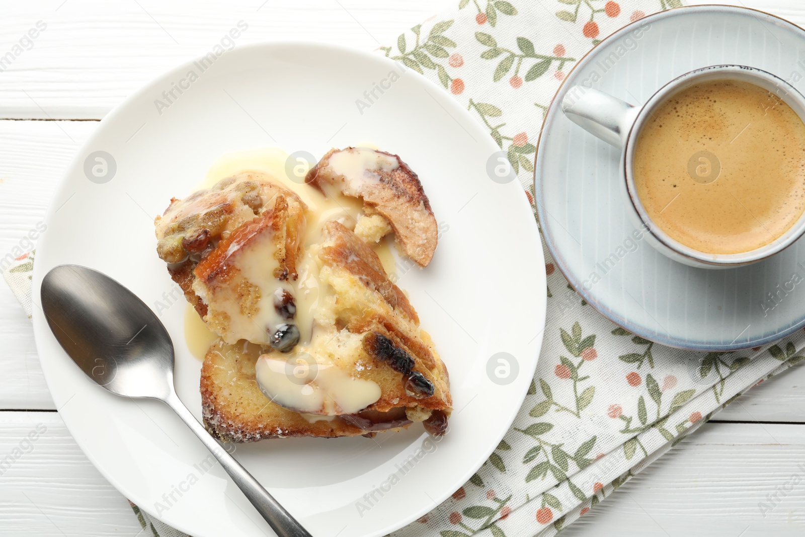 Photo of Freshly baked bread pudding and coffee on white wooden table, top view