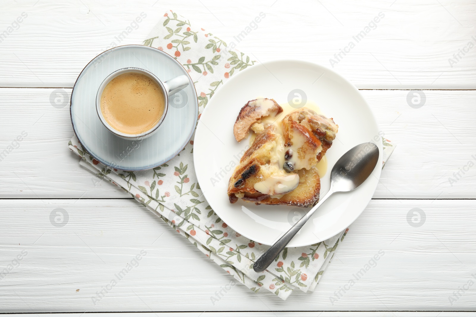 Photo of Freshly baked bread pudding and coffee on white wooden table, top view