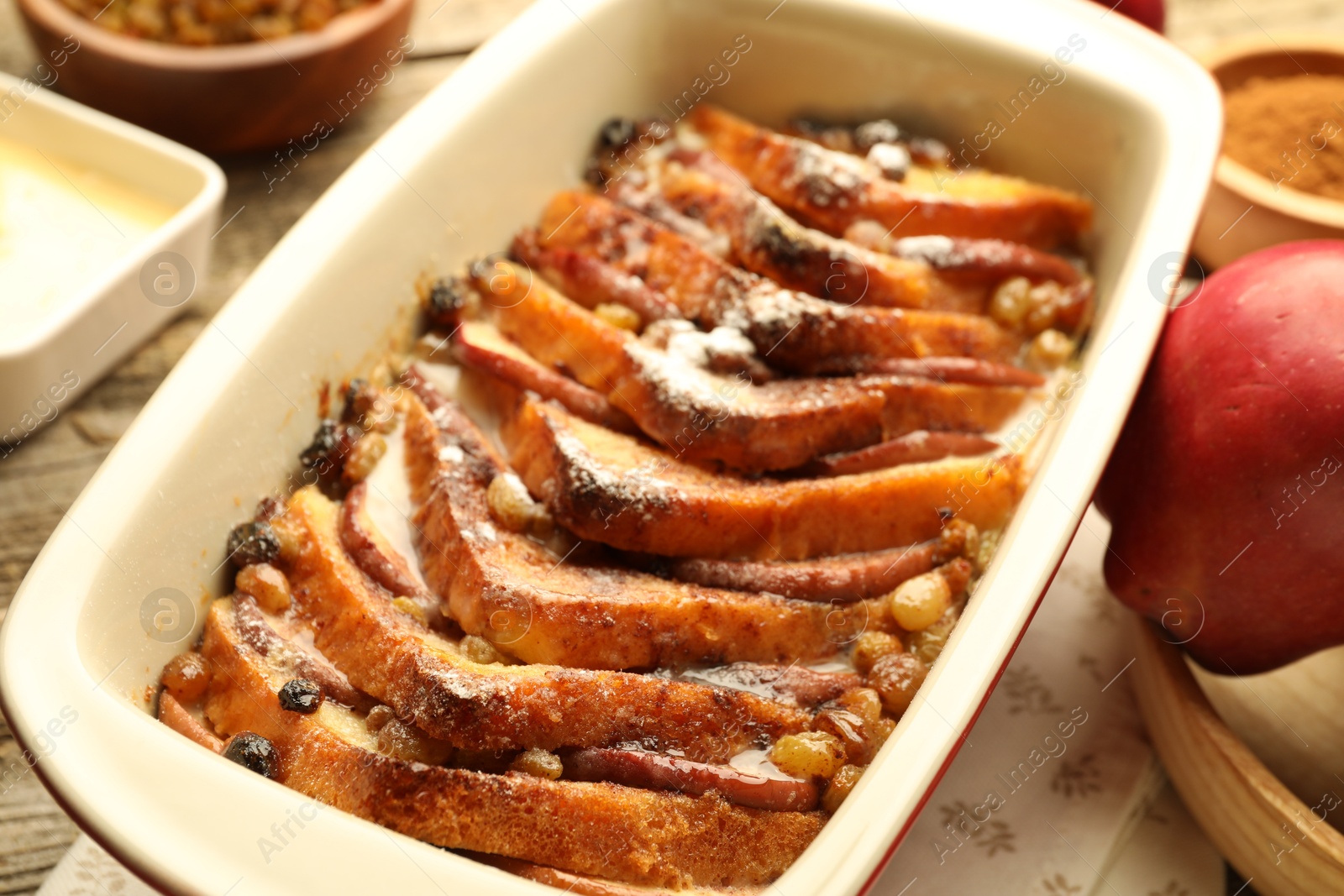 Photo of Freshly baked bread pudding in baking dish on table, closeup