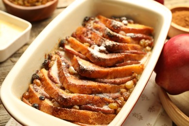 Photo of Freshly baked bread pudding in baking dish on table, closeup