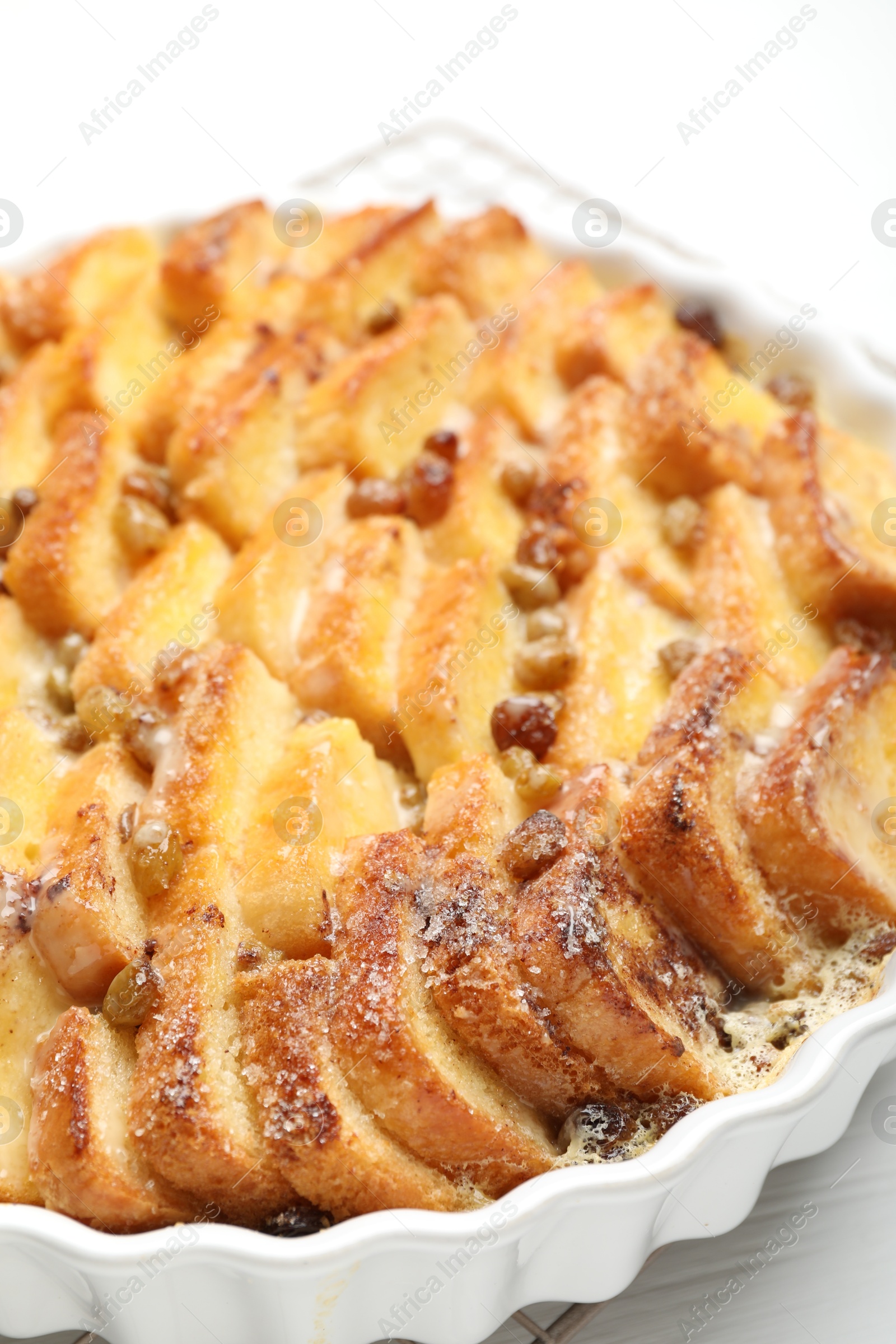 Photo of Delicious bread pudding with raisins on white table, closeup